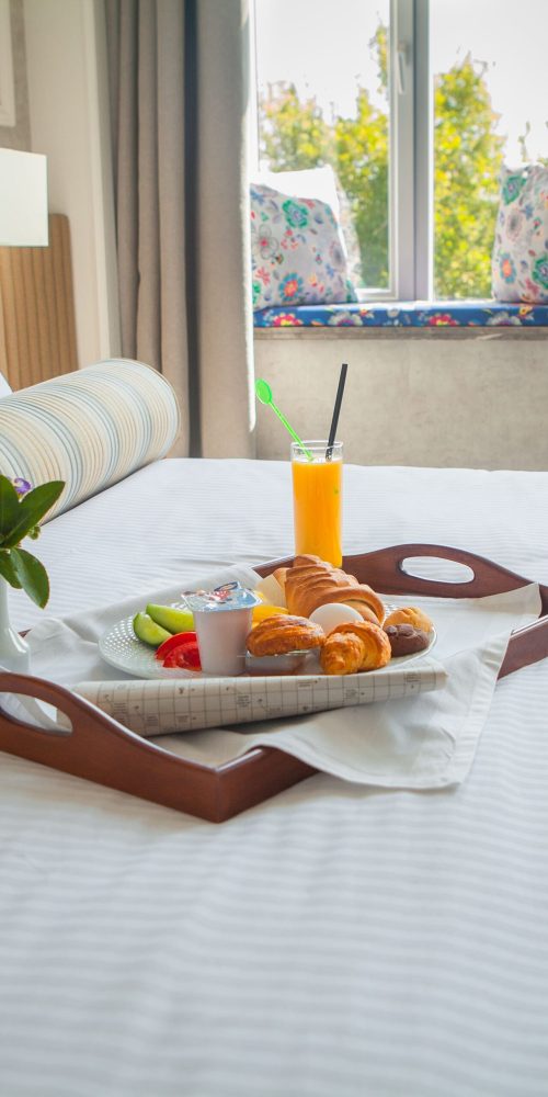 croissant oeuf a la coque jus d orange petit dejeuner au yaourt sur plateau au lit dans la chambre d hotel min